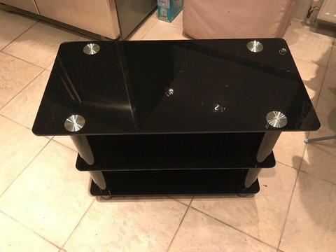 Tv stand black glass. Excellent condition 70cm by 35cm £25 NO OFFERS.CAN DELIVER