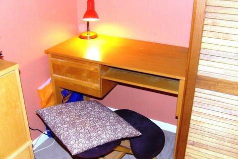 Small desk, kneeling seat and angle-poise lamp
