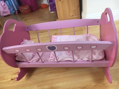 Pink wooden baby dolls cradle with bedding