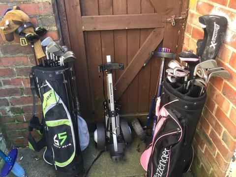 2 sets of golf clubs and 2 trolleys