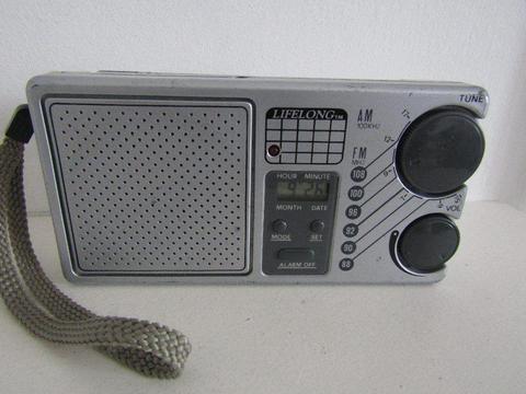 AM/FM POCKET/PORTABLE RADIO WITH CLOCK AND ALARM. WORKS GREAT! WITH CARRY STRAP