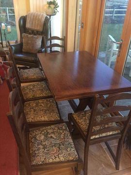 Oak Dining room table, 6 chairs. Extendable, with seat covers. Dark solid oak
