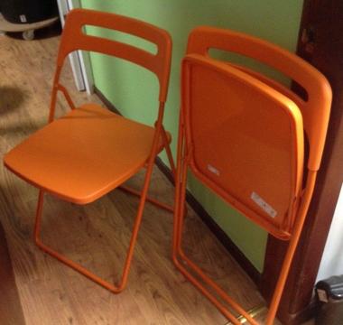 2 orange folding chairs