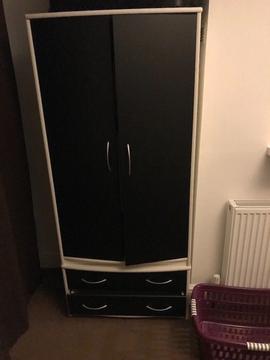 A two door black and white wardrobe with draws