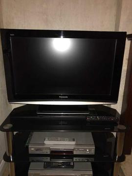 A Panasonic Tv and black glass stand. 32’