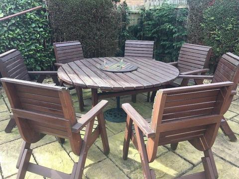 Wooden circular table with matching wooden 7 x chairs. Can remain outdoors all year round.