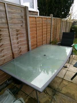 Glass top patio table with six folding chairs