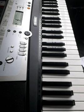 Yamaha keyboard with stand and music book